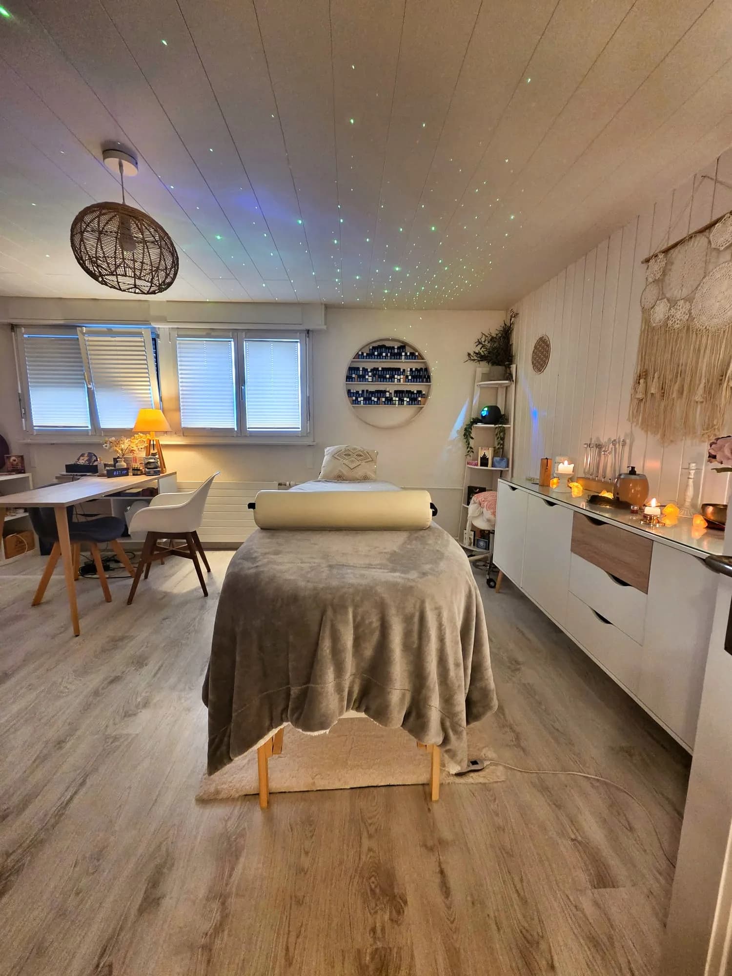 Salle de massage du cabinet avec table de soin et ciel étoilé au plafond